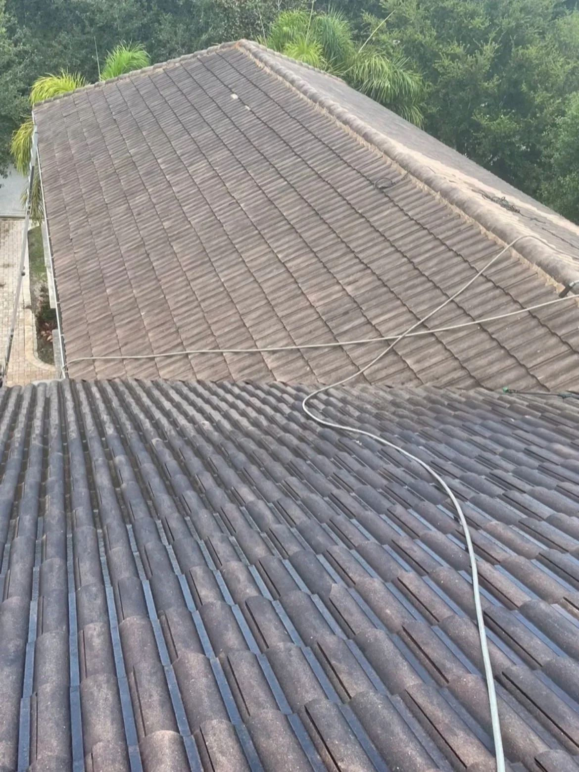 Before roof cleaning showing dirty tile roofing on a South Florida home.