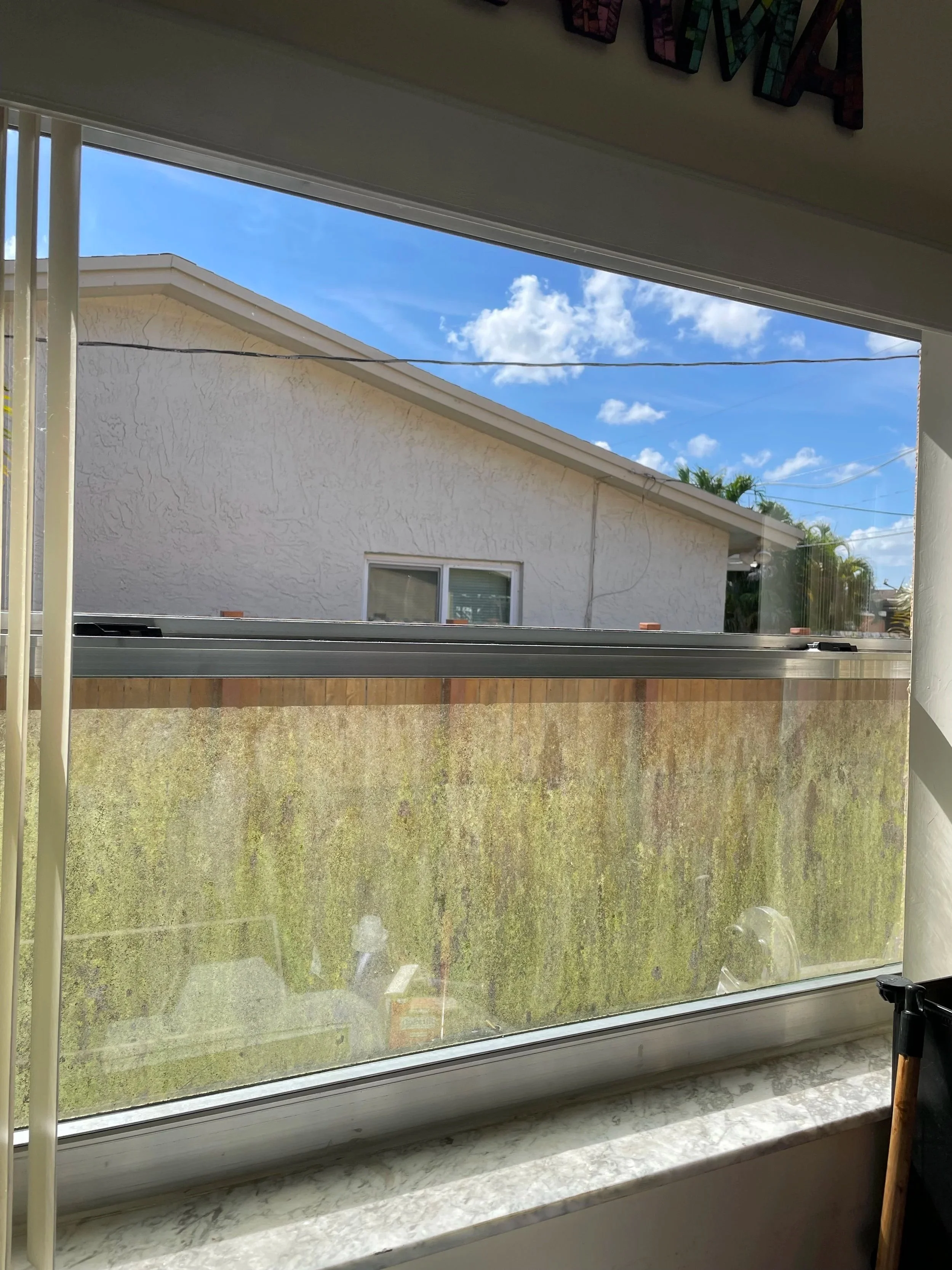Before window cleaning showing a dirty window screen at a South Florida home.
