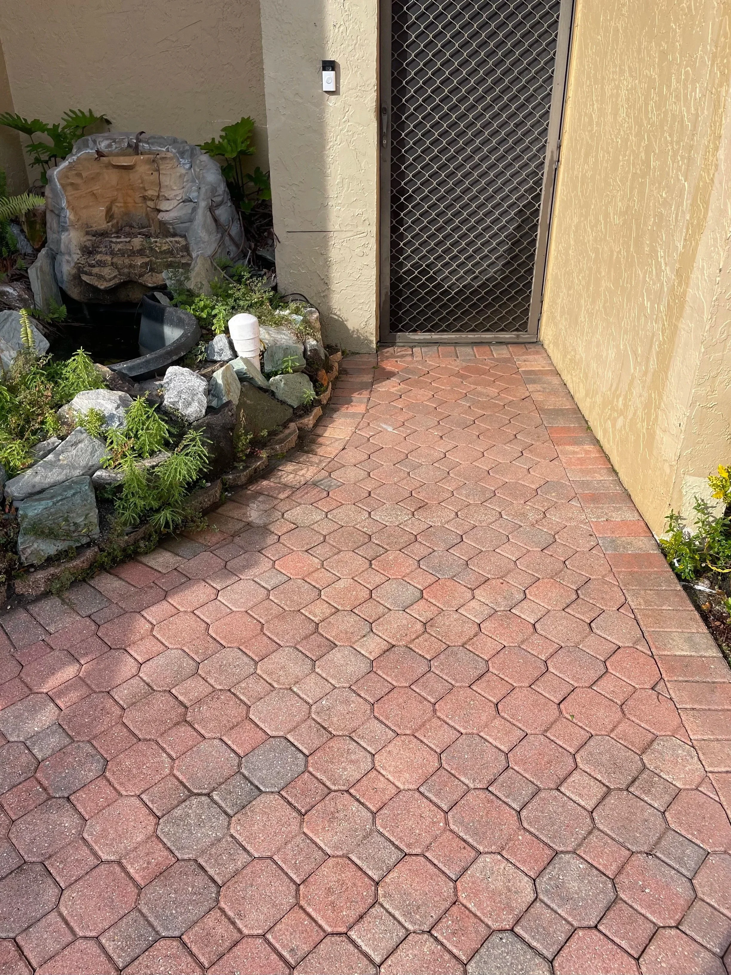 After professional pressure washing showing a clean brick paver front entrance.