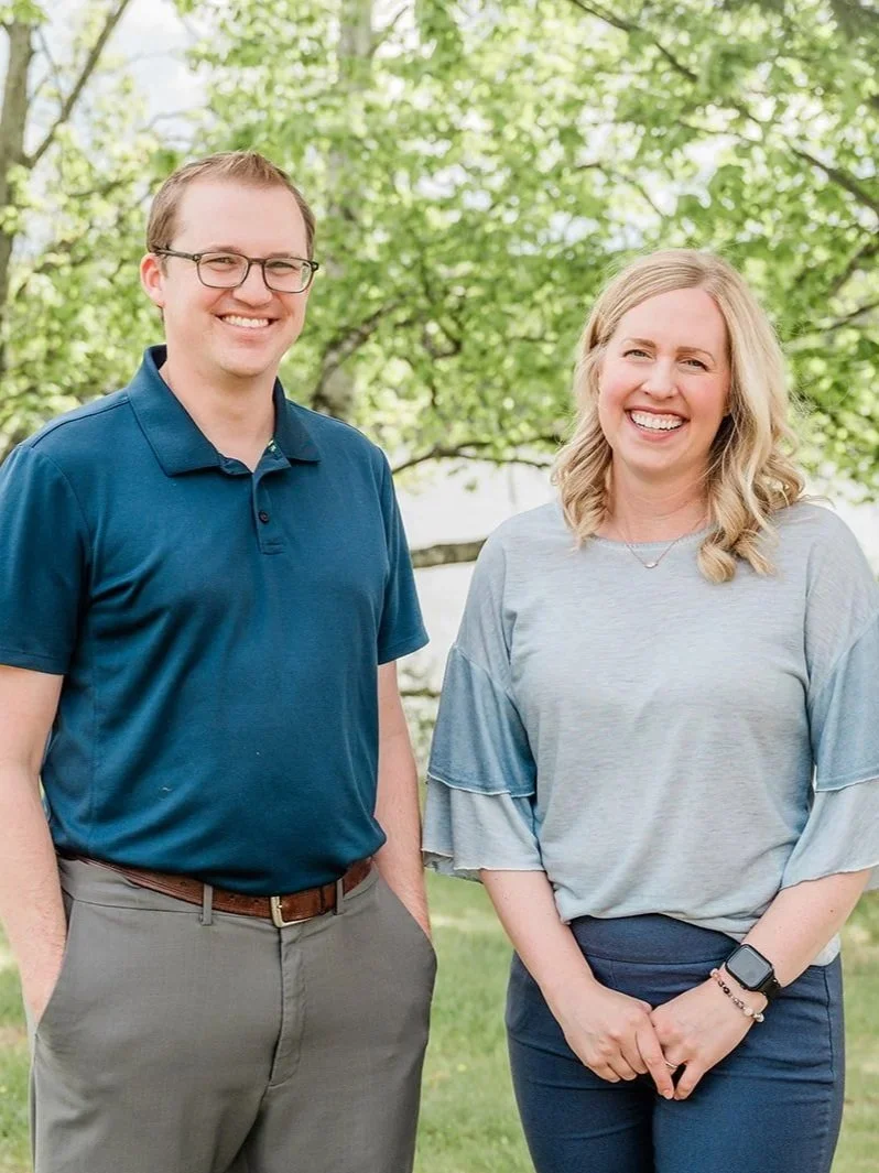 Dr. Brad Camp and Dr. Bree Highstrom are smiling outside of the Legacy Family Dental office in Eagle River, Wisconsin.