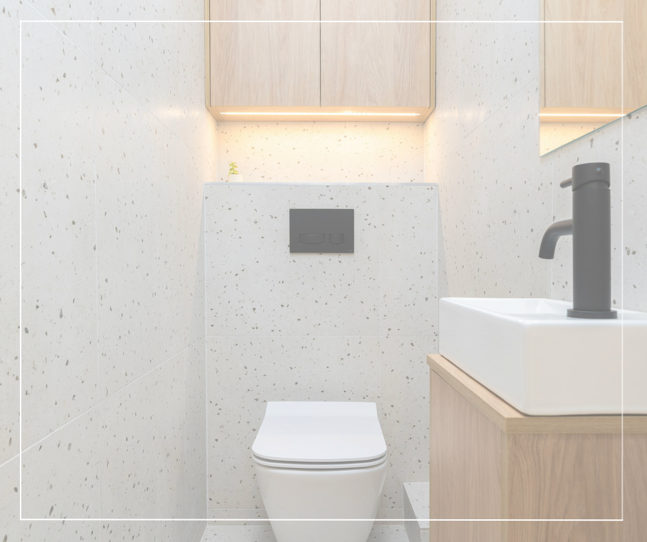 Modern minimalist bathroom with a white toilet, a square vessel sink with black faucet, wooden cabinet, speckled beige walls, and recessed lighting.