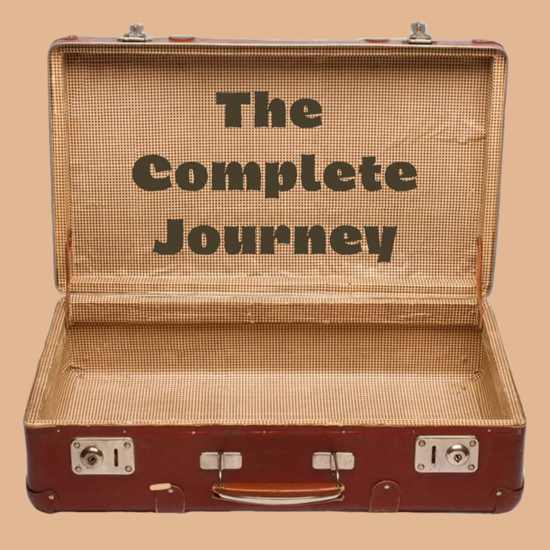 An open vintage suitcase with the words "The Complete Journey" inside the lid.