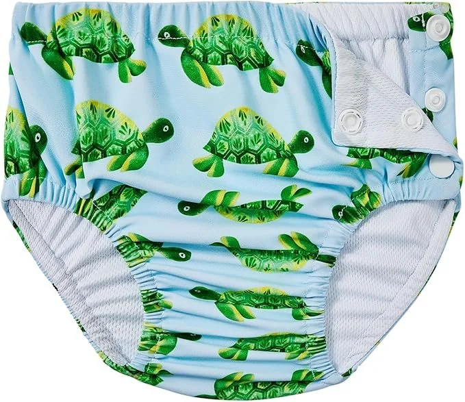 Cloth diaper with a green turtle print on a light blue background.