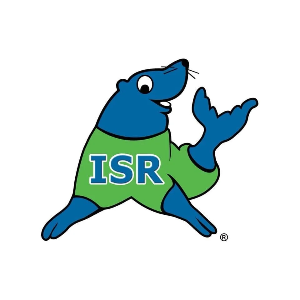 A cartoon blue seal wearing a green shirt with 'ISR' on it, making a peace sign with its hand.