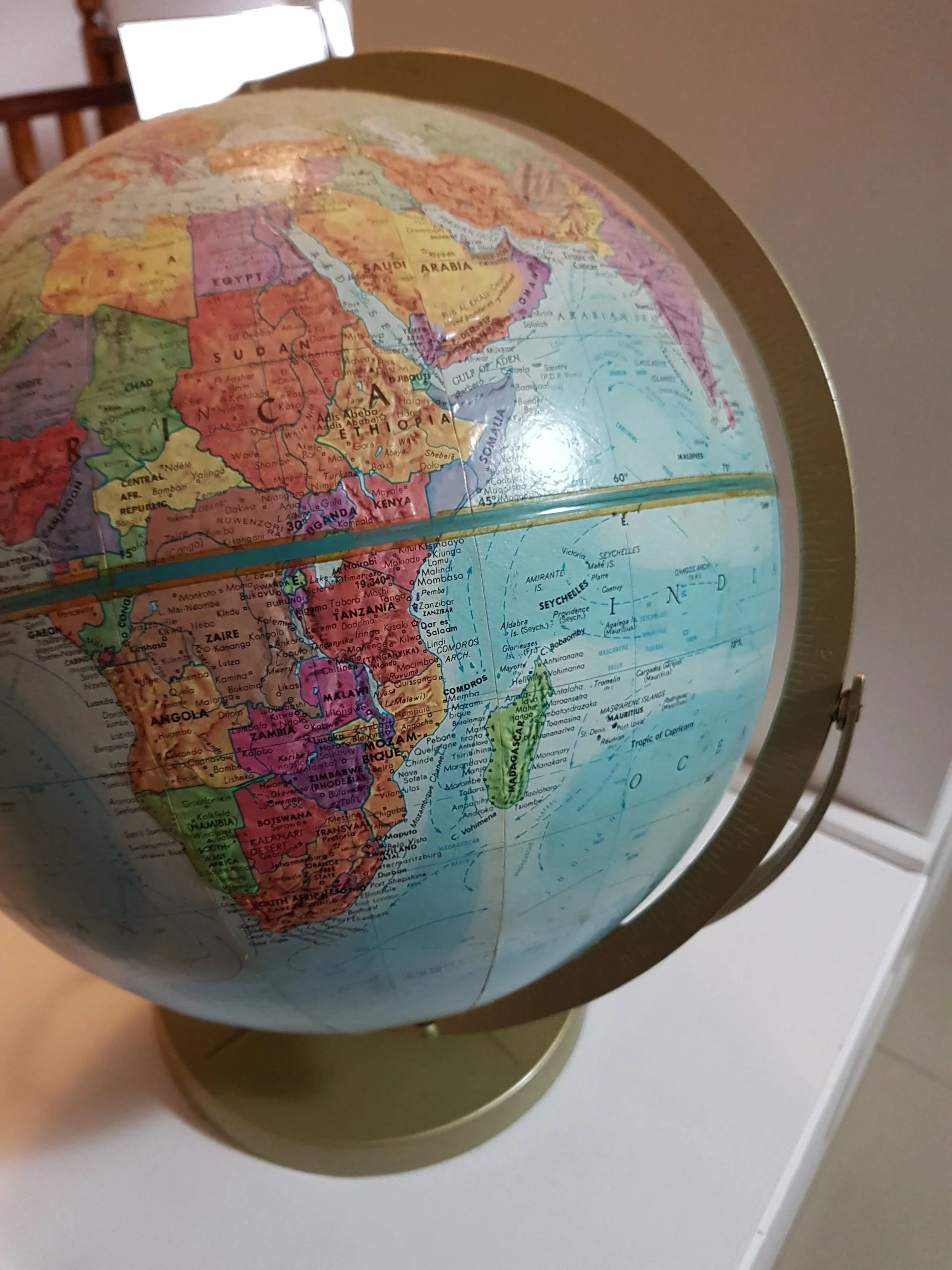 A globe displaying Africa and parts of the Middle East, with visible countries including Egypt, Saudi Arabia, Ethiopia, and Kenya. The globe is mounted on a stand and blurs into the background.