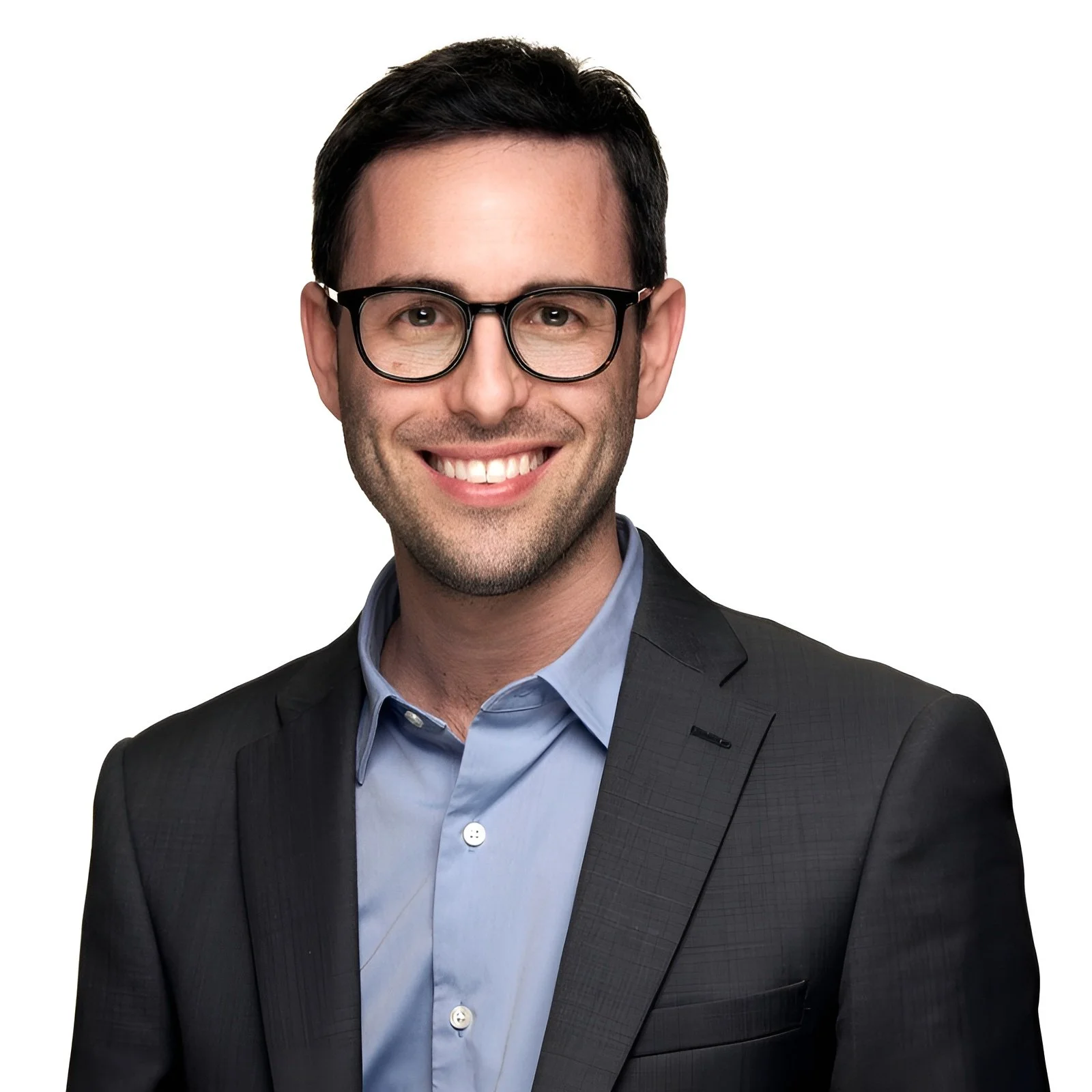 A man with dark hair, wearing glasses, a blue dress shirt, and a dark suit jacket, smiling against a plain white background.