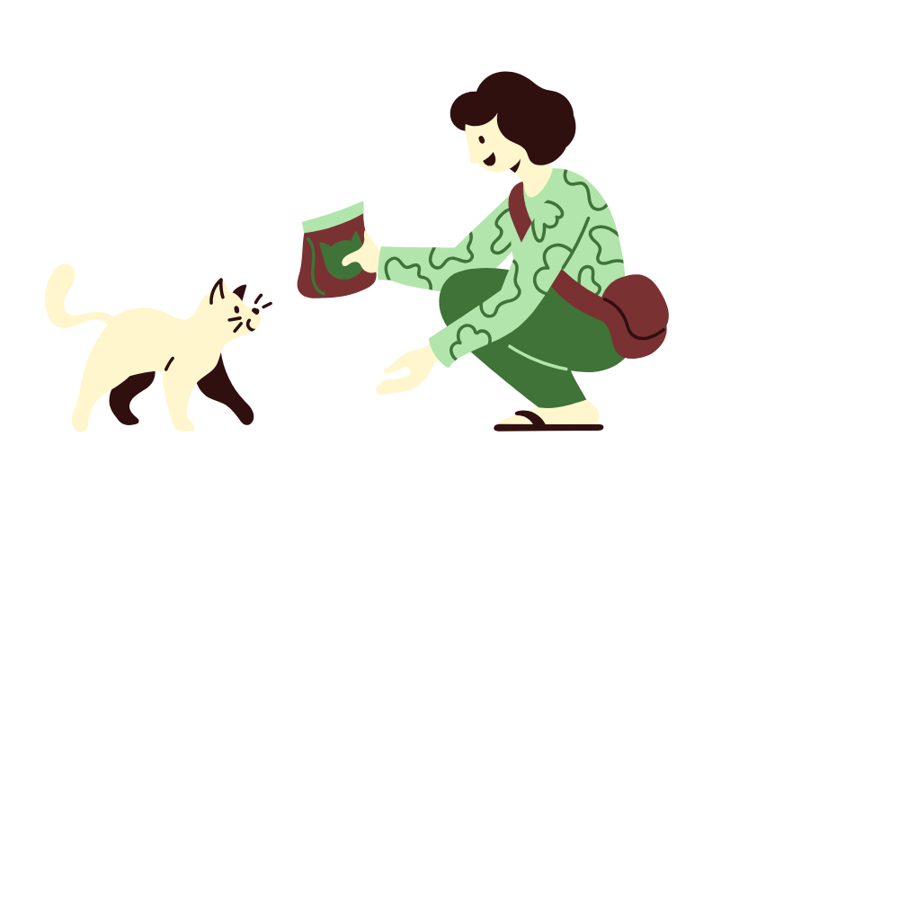 Person crouching on a large white flower-shaped surface, feeding a cream-colored cat with a bag of cat food.