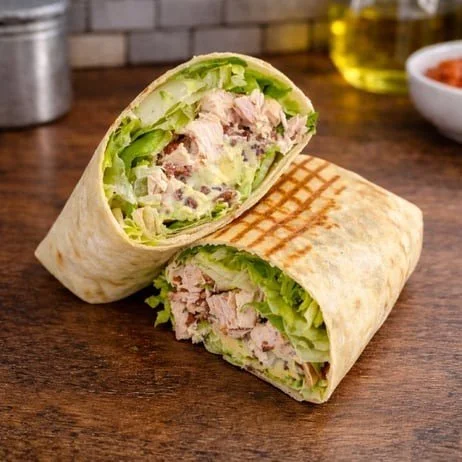 Chicken wrap cut in half showing lettuce, chicken, and other ingredients inside