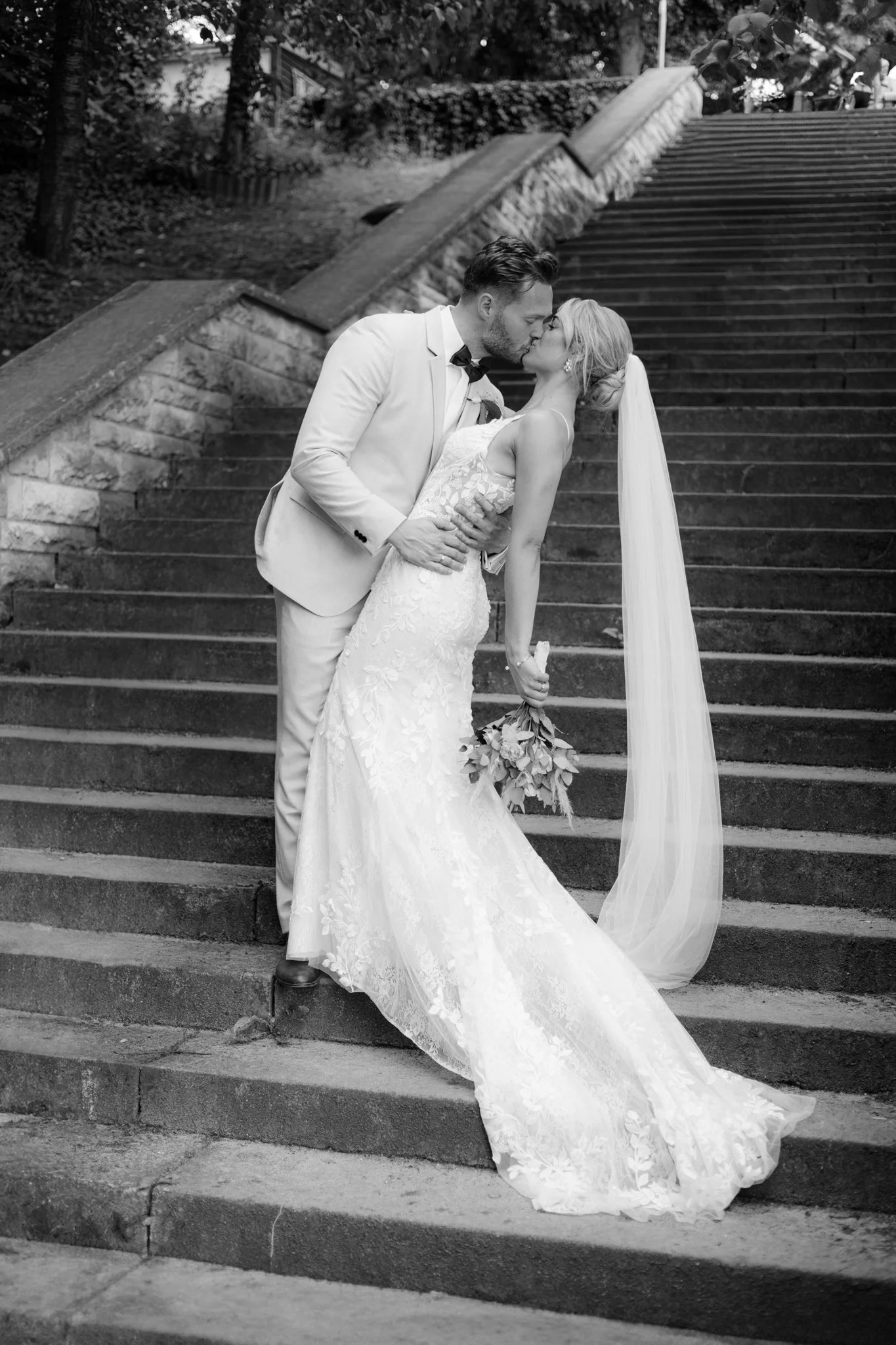 Brautpaar küsst sich auf einer Treppe nach der Hochzeit in Berlin.