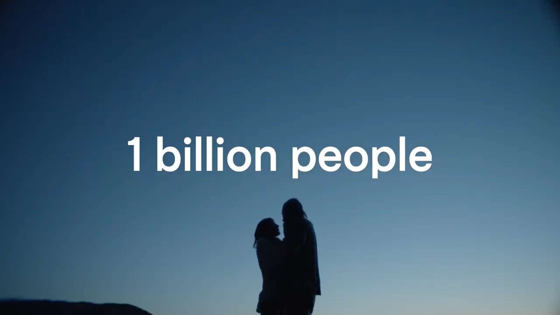 Silhouette of two people, possibly a mother and child, standing close together against a blue sky with the text '1 billion people' on the image.