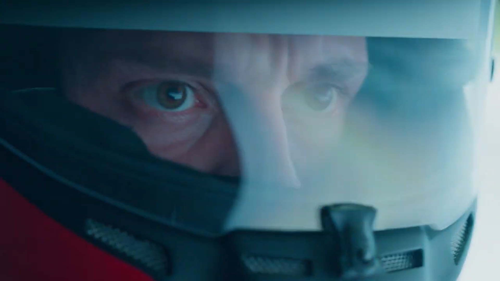 Close-up of a person wearing a helmet with a transparent visor, showing their focused eyes as they look ahead.