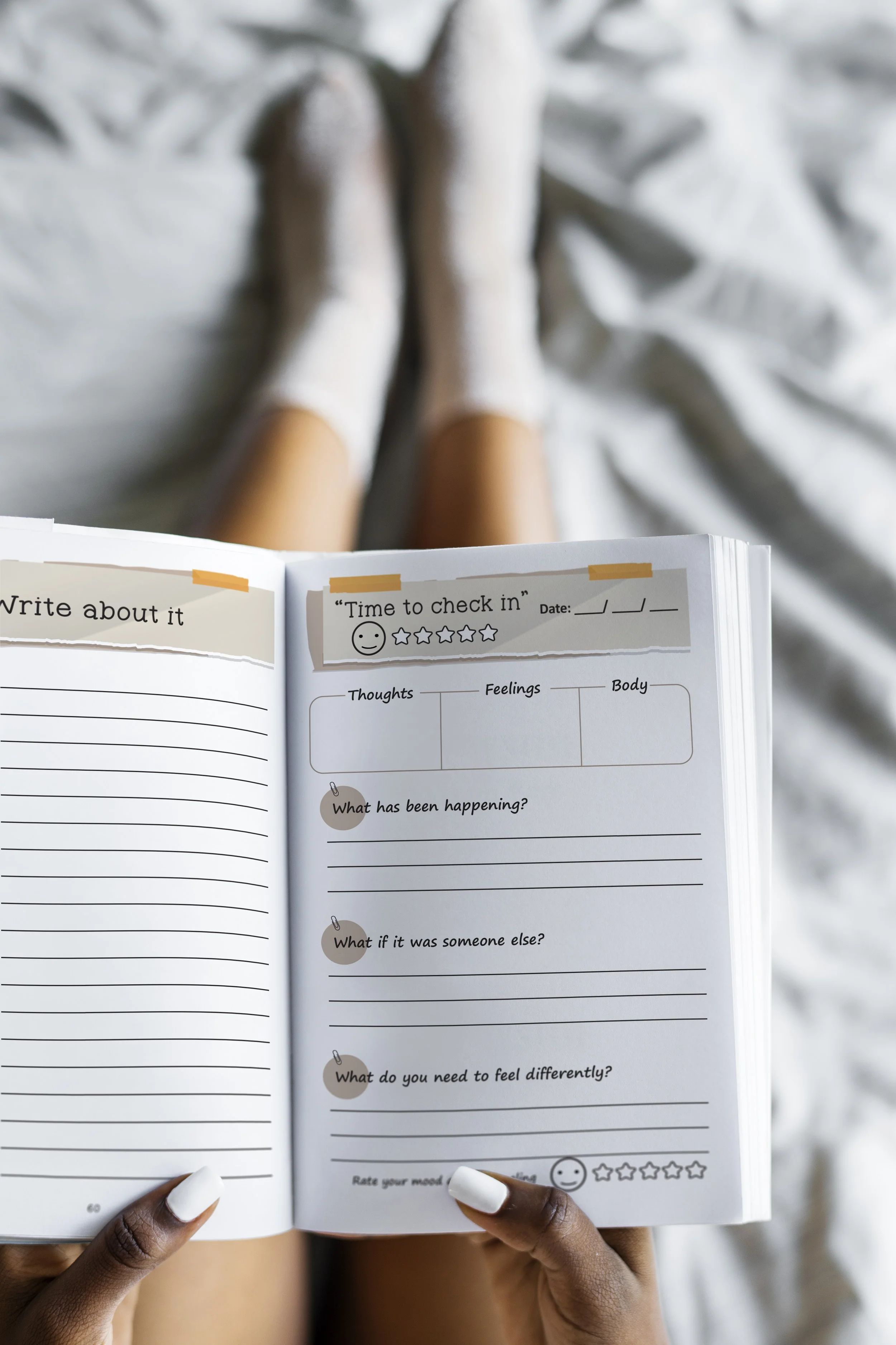 Person with dark skin holding an open journal or planner with prompts, sitting on a bed with white sheets, legs visible, wearing a white sock, and having white painted nails.

"Time to Check In" by Victoria C. Neil