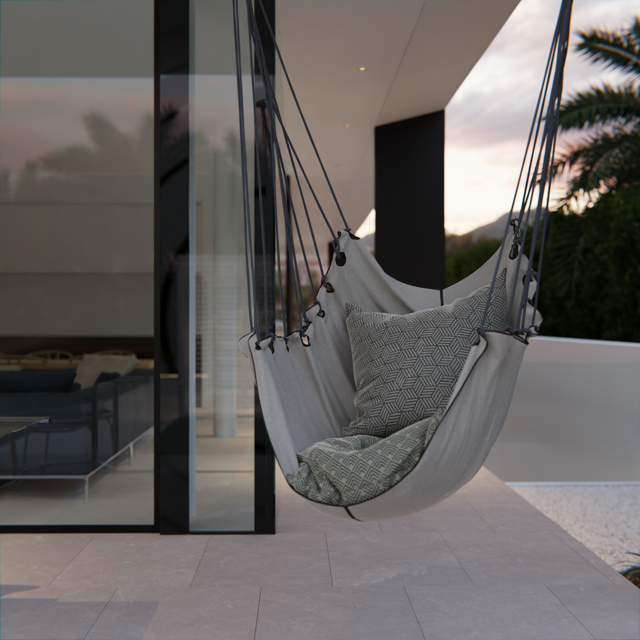 Angolo di un balcone o terrazza con una sedia a dondolo in tessuto, vicino a una parete di vetro e una pianta di palma, in un'ambientazione moderna e luminosa al tramonto.