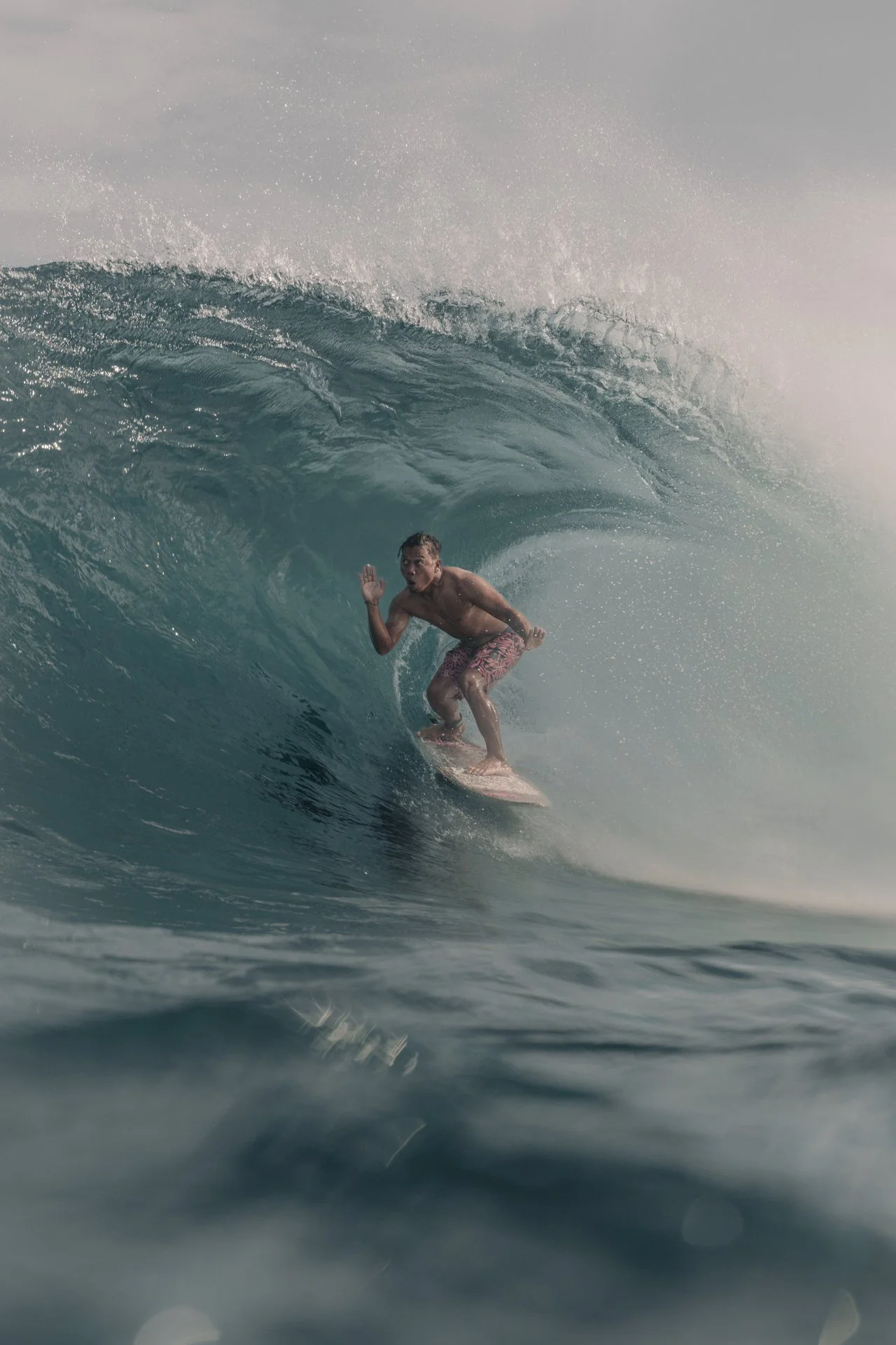 Surfer riding inside a barrel wave in open ocean conditions.