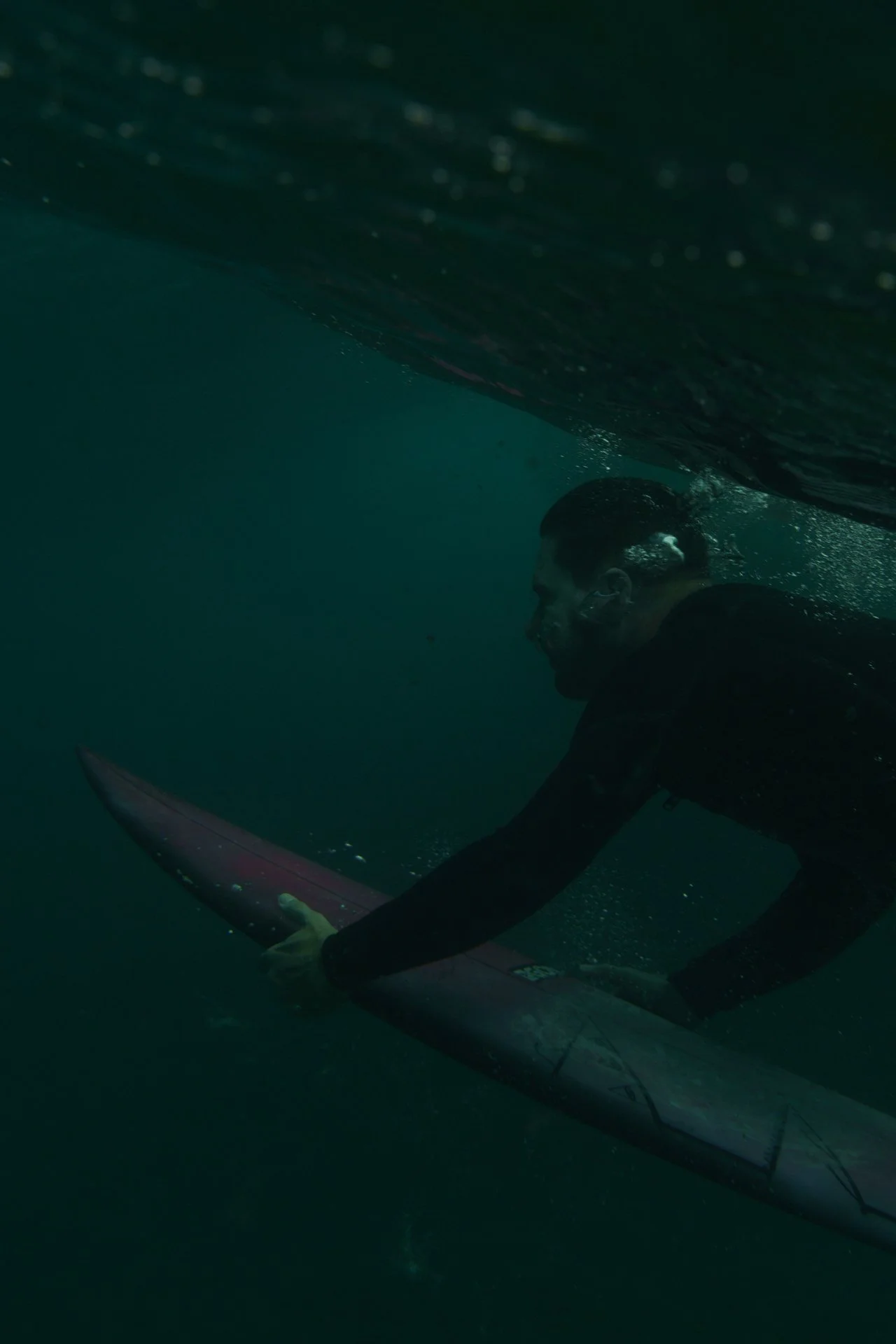 Underwater view of a surfer duck diving beneath the surface.