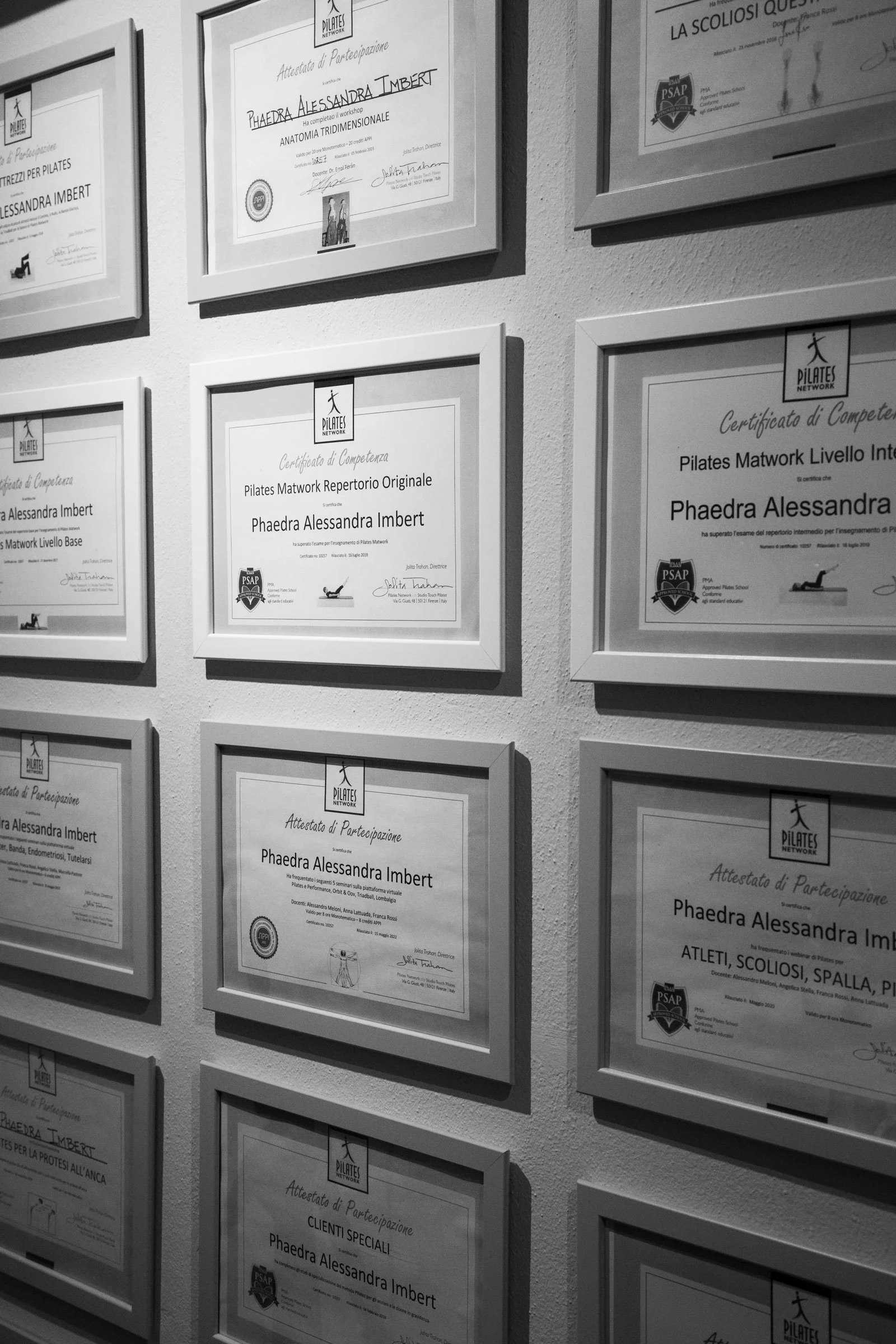 Wall at Phaedra Pilates Studio in Lugano displaying framed certification, seminar and workshop certificates for Phaedra Imbert Jost.