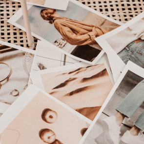A scattered collection of printed photographs featuring women, fashion, and portraits.