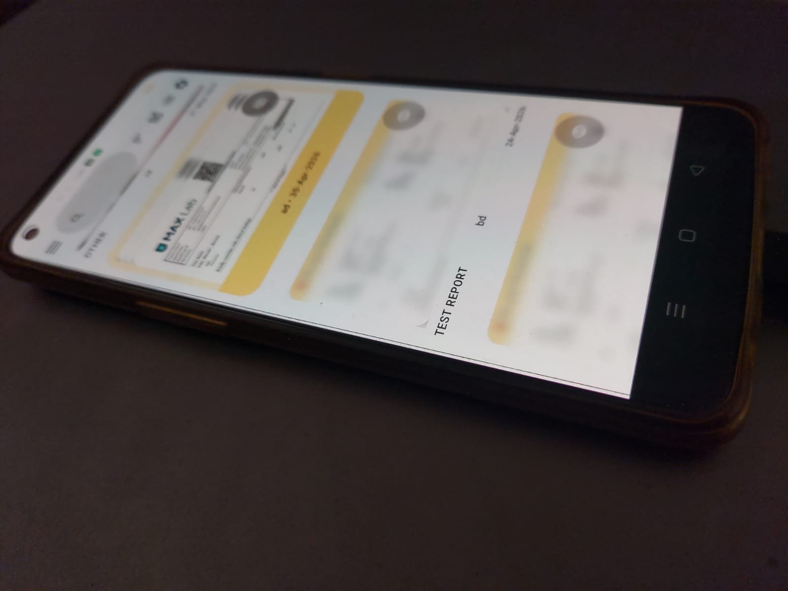 A smartphone displaying a flight boarding pass or ticket with some details blurred, lying on a dark surface.
