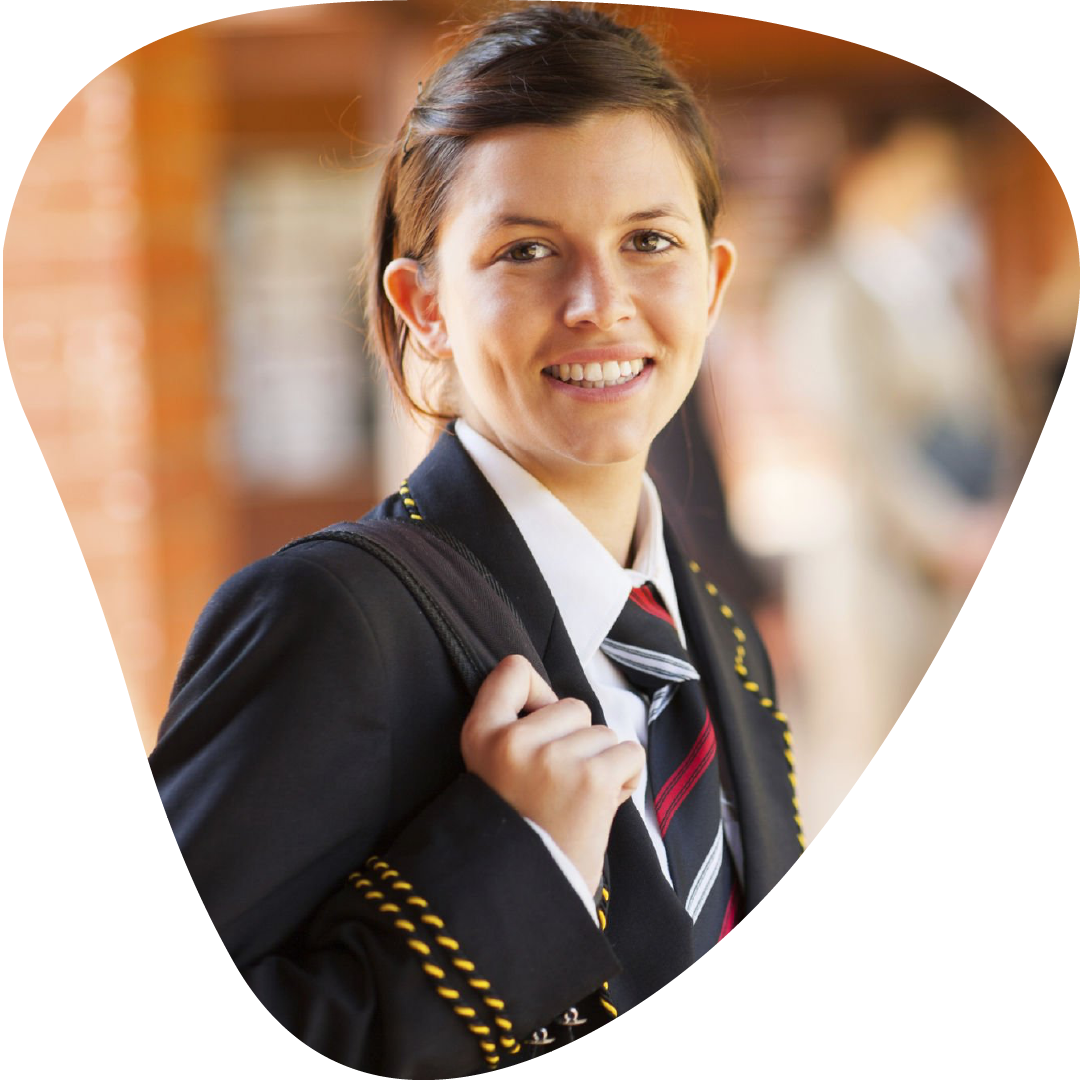 A female young student in a school uniform smiling and carrying a backpack.