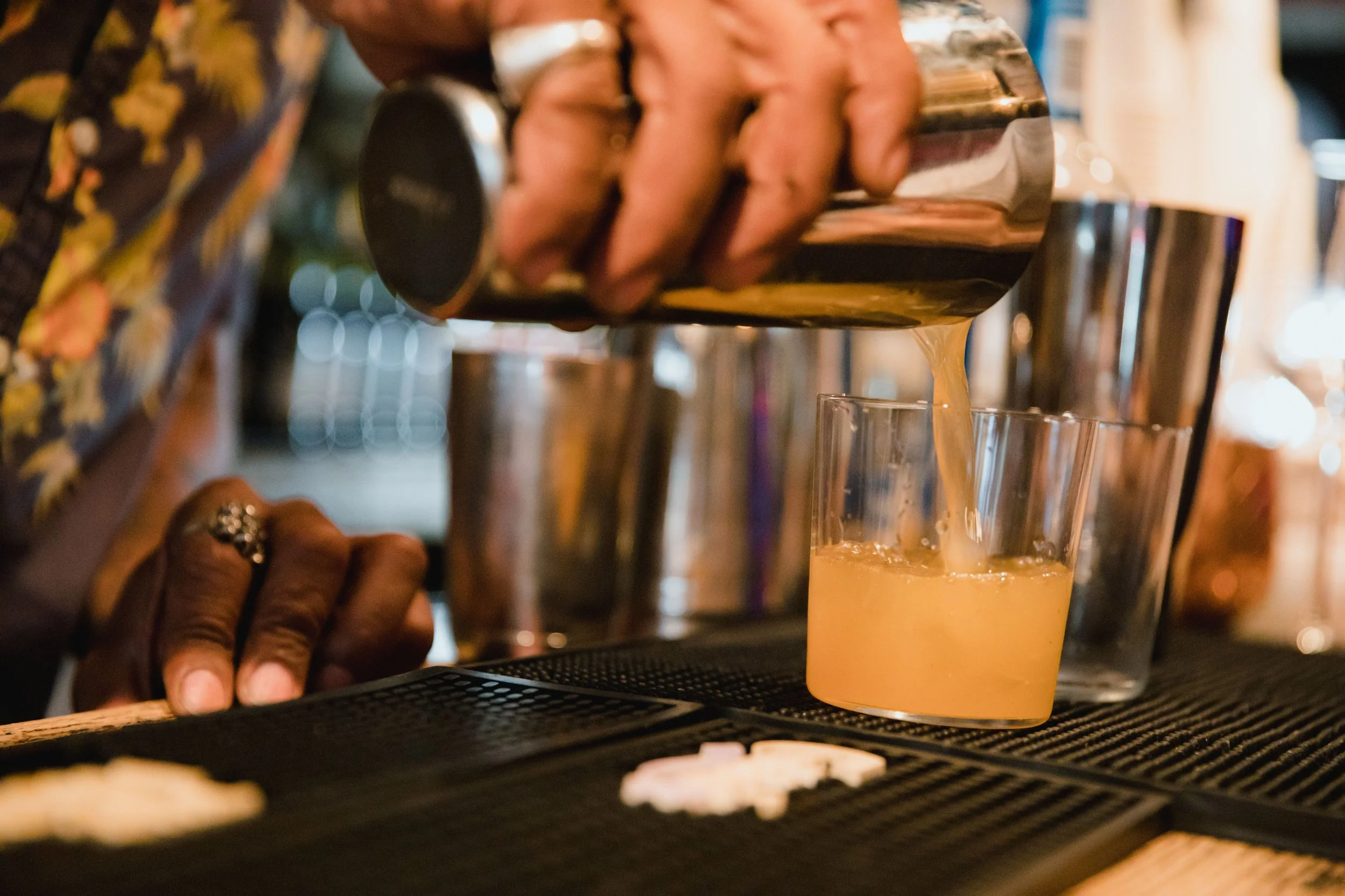Person pouring beer from tap into a glass in a bar or brewery setting.