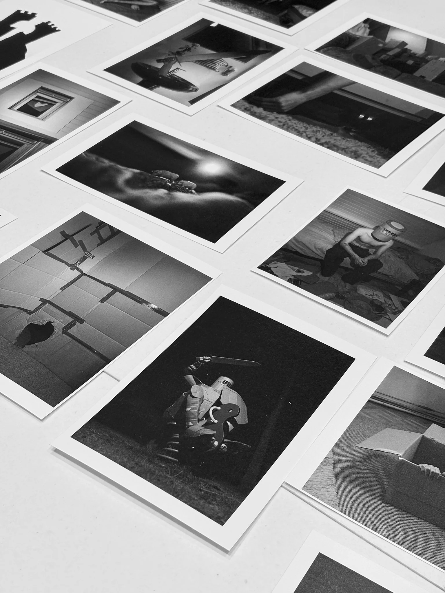 A close-up of photographic prints laid out in a grid across a table.