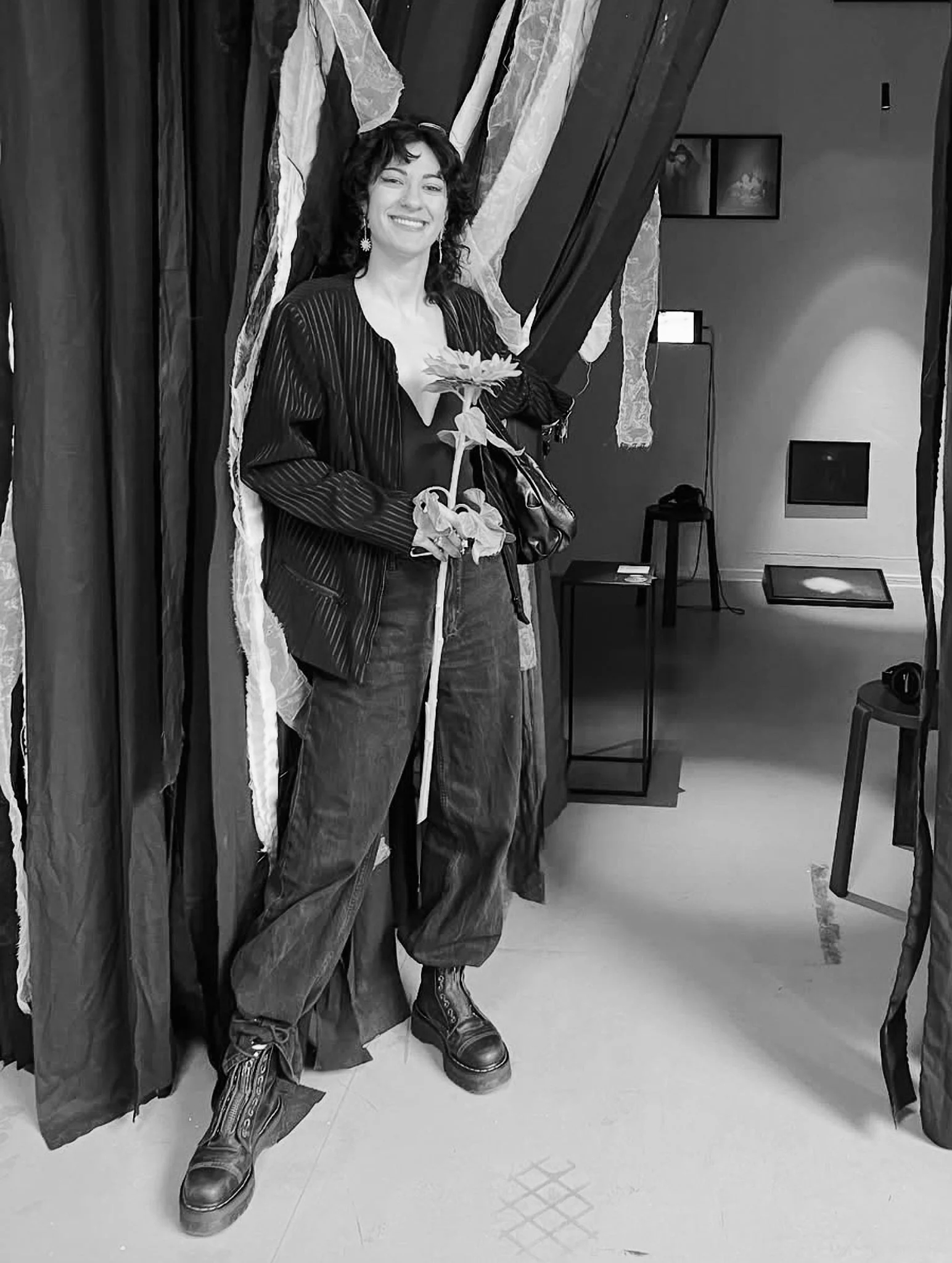 Portrait of Aline Papenheim, co-founder of Wanderstories, holding a sunflower in an exhibition space.