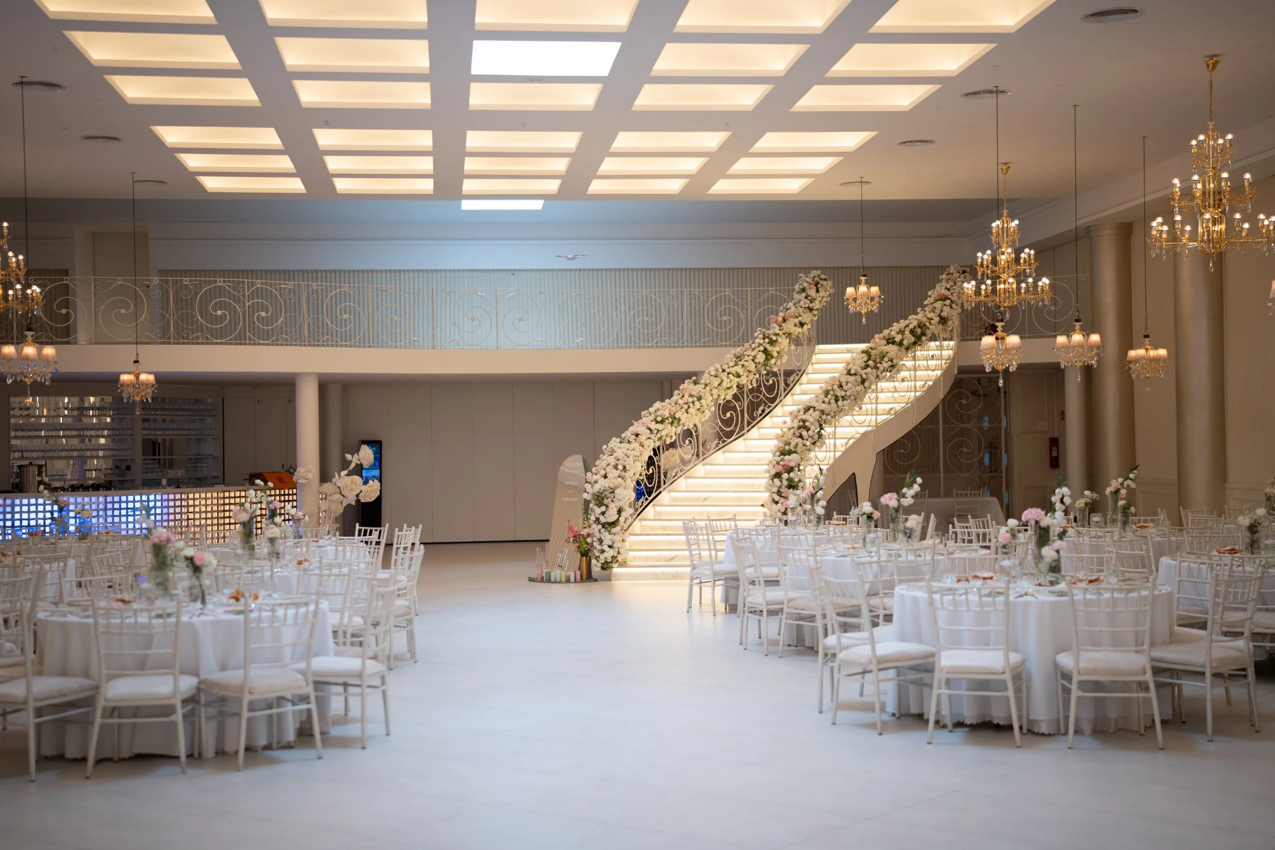 Golden Hall mit geschmückter Treppe, Balkon und runden Tischen für Hochzeiten, Galas und Firmenfeiern in Norddeutschland / Hamburg