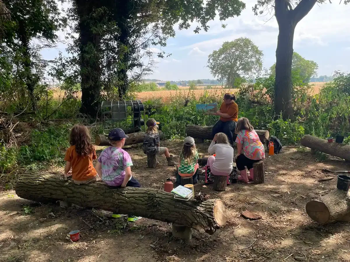 Children gathering in circle with Emma at Eyton Burrow woods 