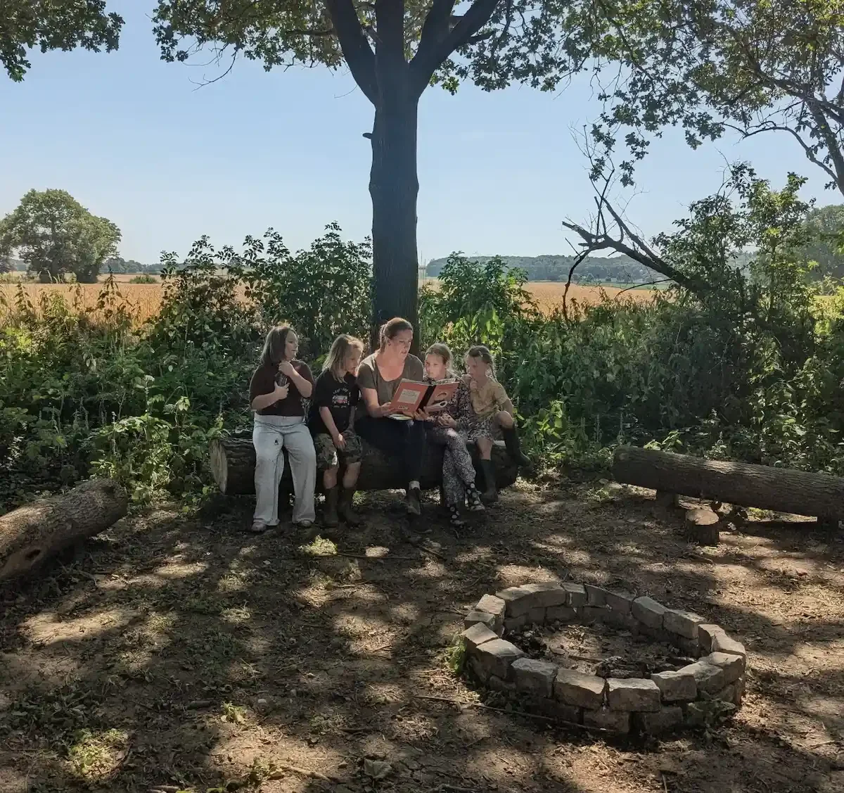 Children and Rachel reading in the woods at Eyon Burrow 