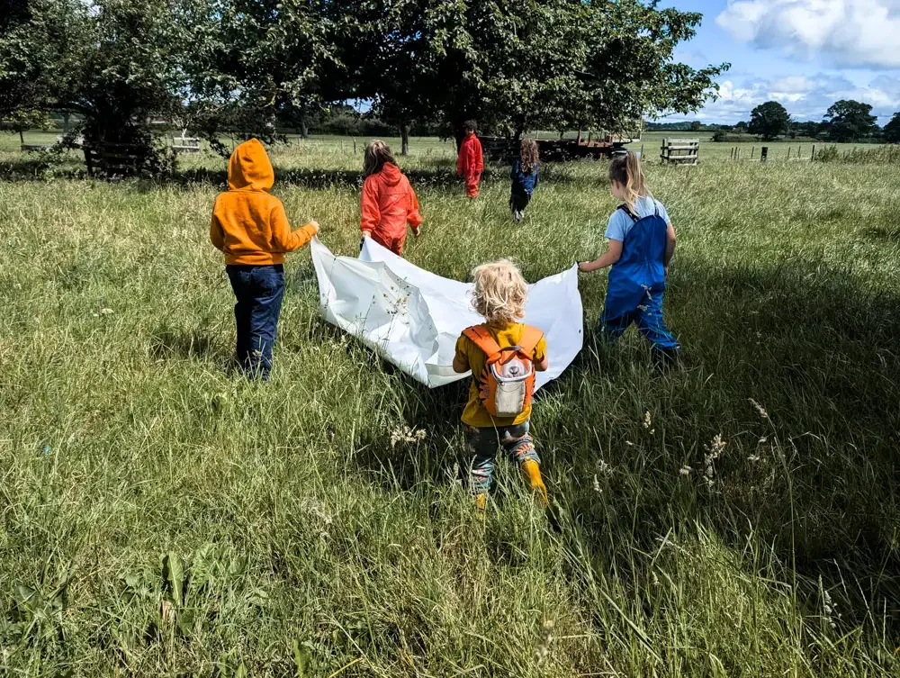 Children in a field holding a sheet at Eyton Burrow 