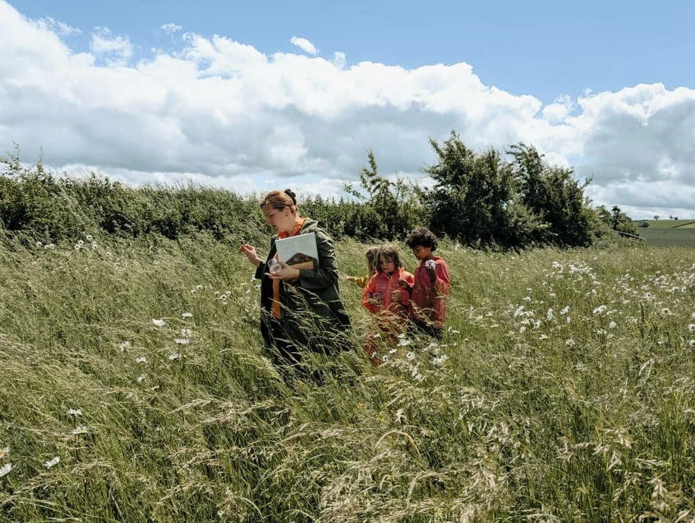 Children and teacher walking through a meadow at Eyton Burrow 
