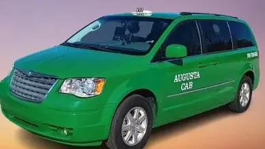 Green Augustush cab minivan with taxi sign on roof