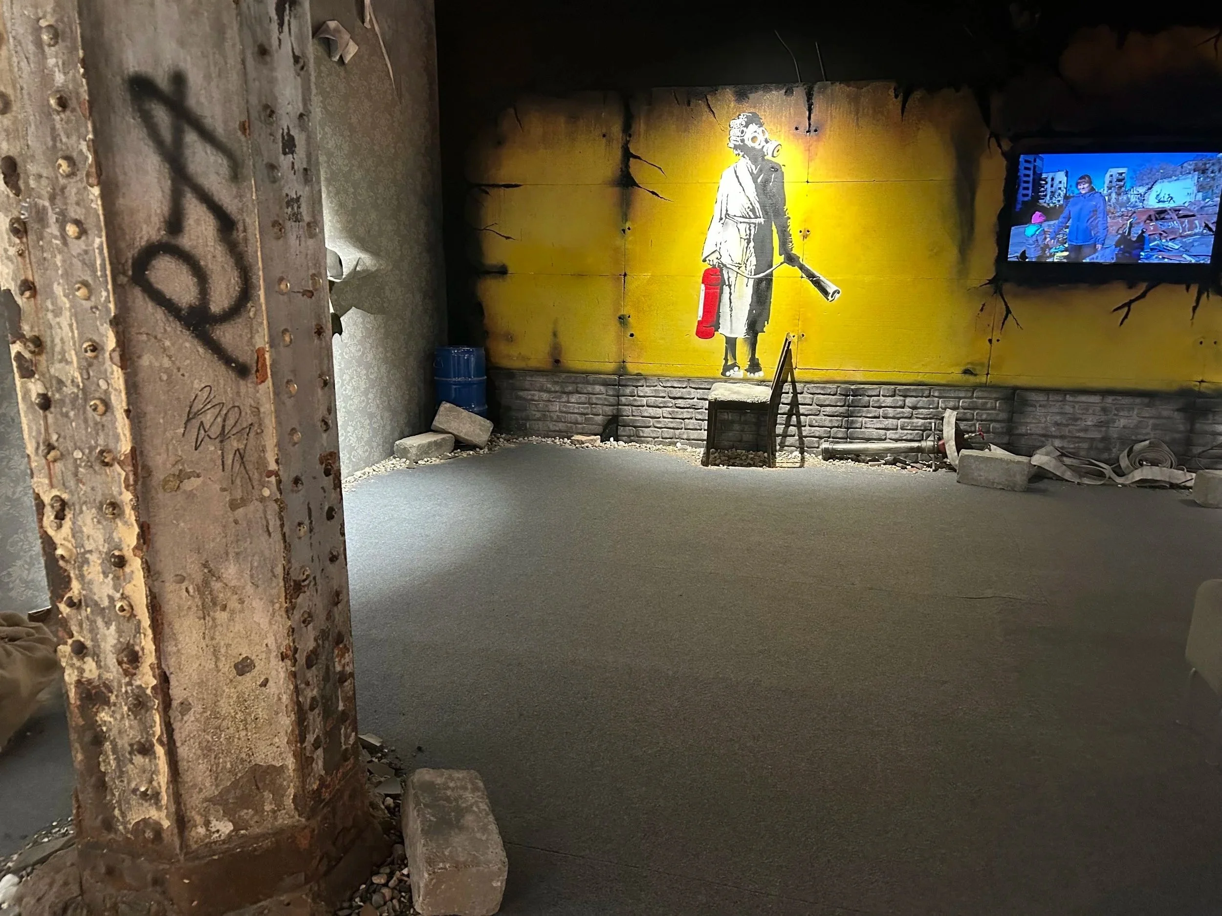 still image of steel pillar and graffiti wall at Banksy exhibition, Mayfield depot, Manchester