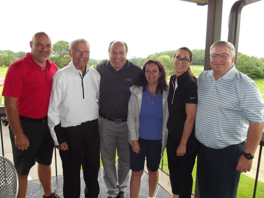 Mayor Steve Pellegrini standing on a balcony overlooking a green golf course with trees in the background.