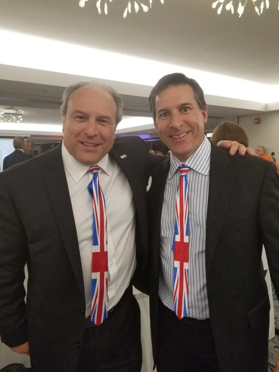 	
Mayor Steve Pellegrini with Union Jack tie smiling and posing at a social event.