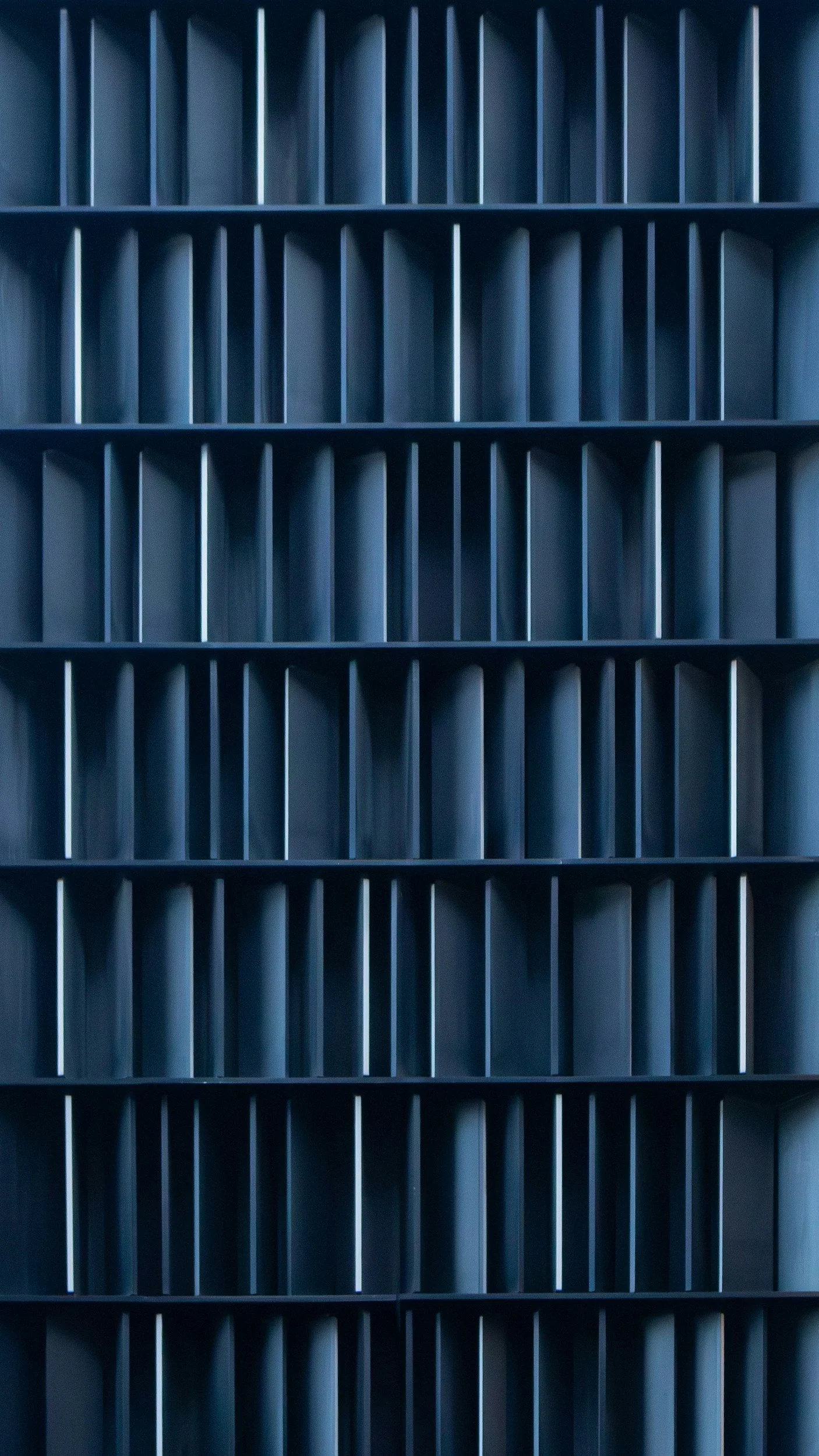 A close-up view of multiple black mail sorting trays or bins arranged in a grid pattern.
