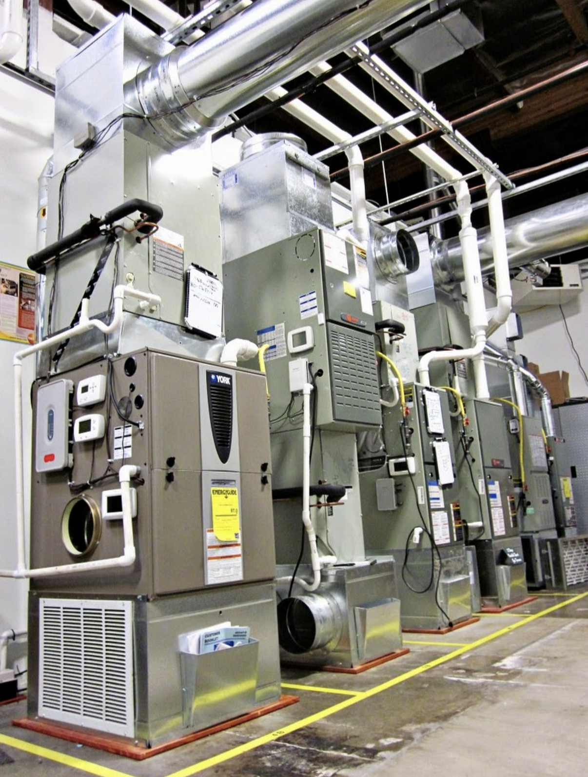 Industrial HVAC equipment with ductwork and control units in a factory setting.