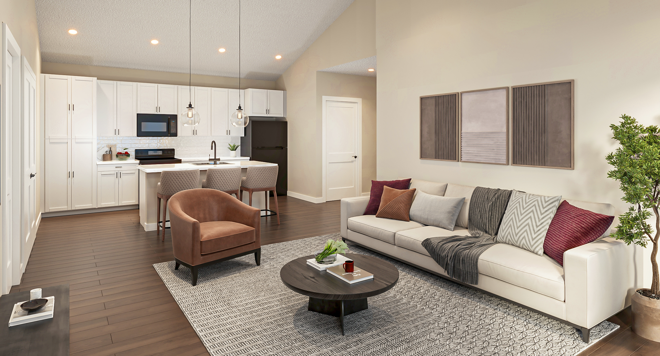 Two-bedroom living room with white sofa, brown armchair, round dark wood coffee table, and patterned rug. Adjacent open kitchen with white cabinets, dark flooring, bar stools, and pendant lights.