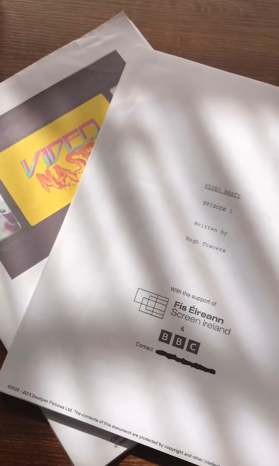A printed script titled "Video Nasty" Episode 1, written by Hugh Travers, supported by Fís Éireann Screen Ireland and BBC, with contact information at the bottom.