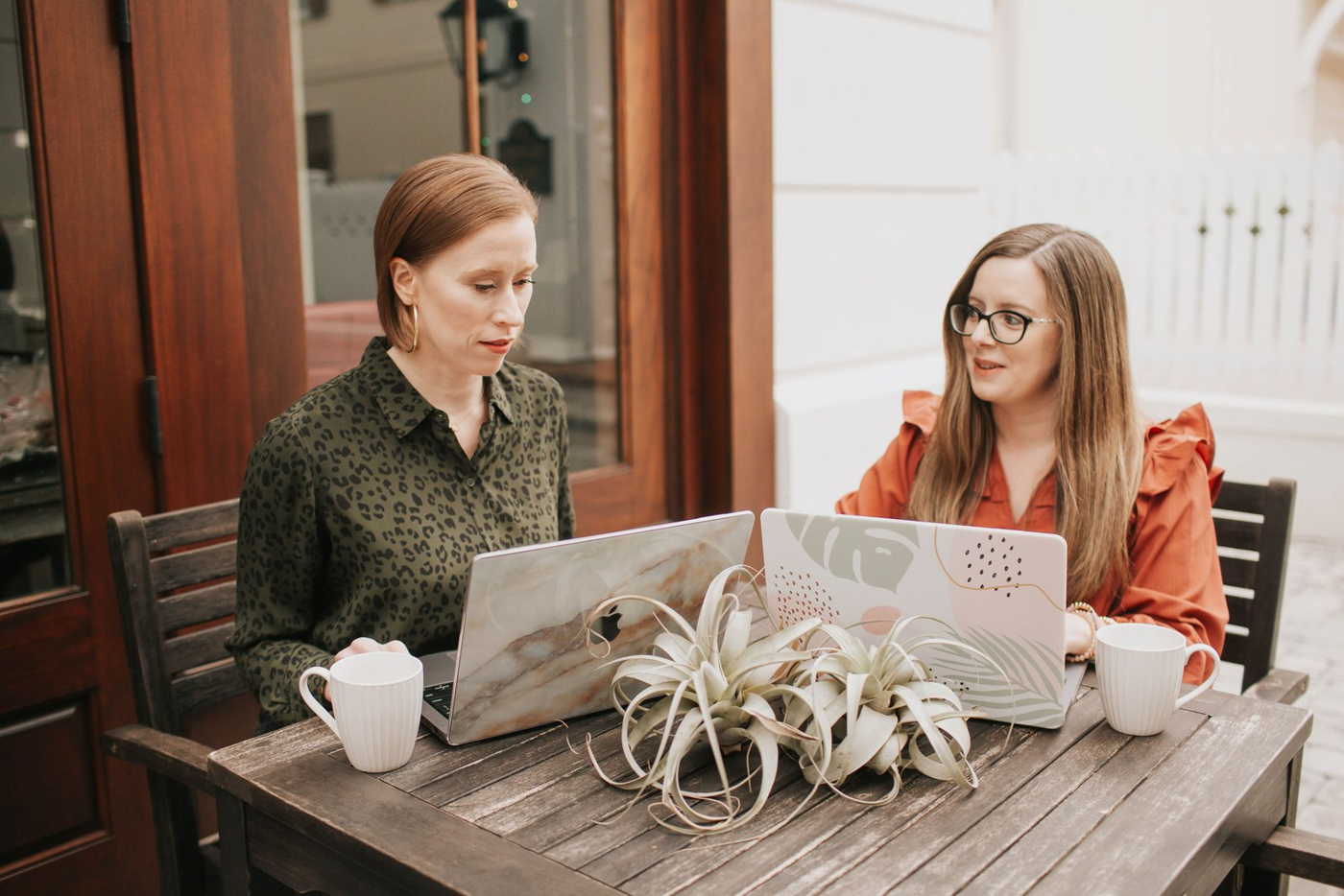 Natalie Clarke talking through a plan with a team member over laptops