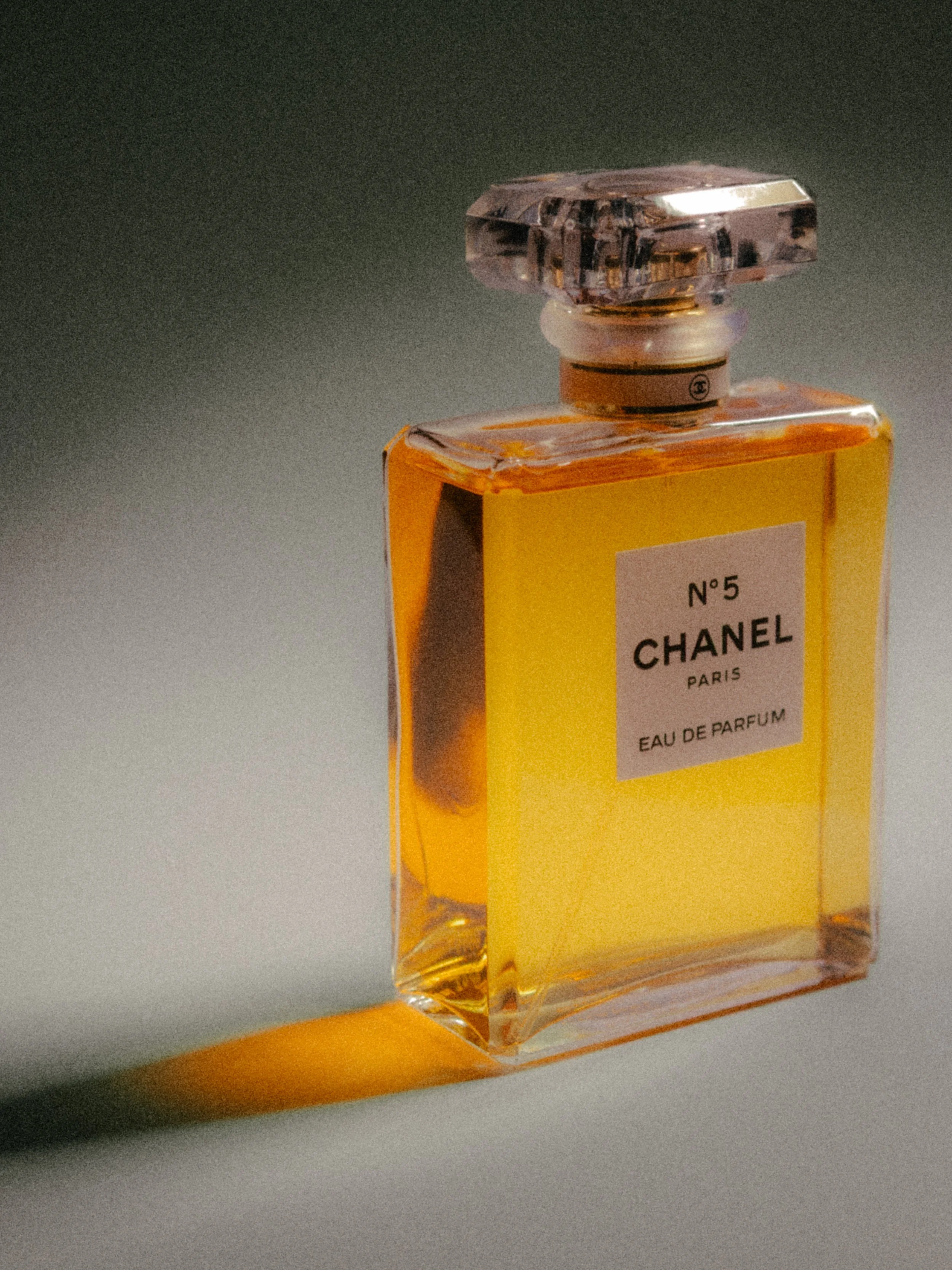A bottle of Chanel No. 5 perfume with a rectangular yellow label on the front.