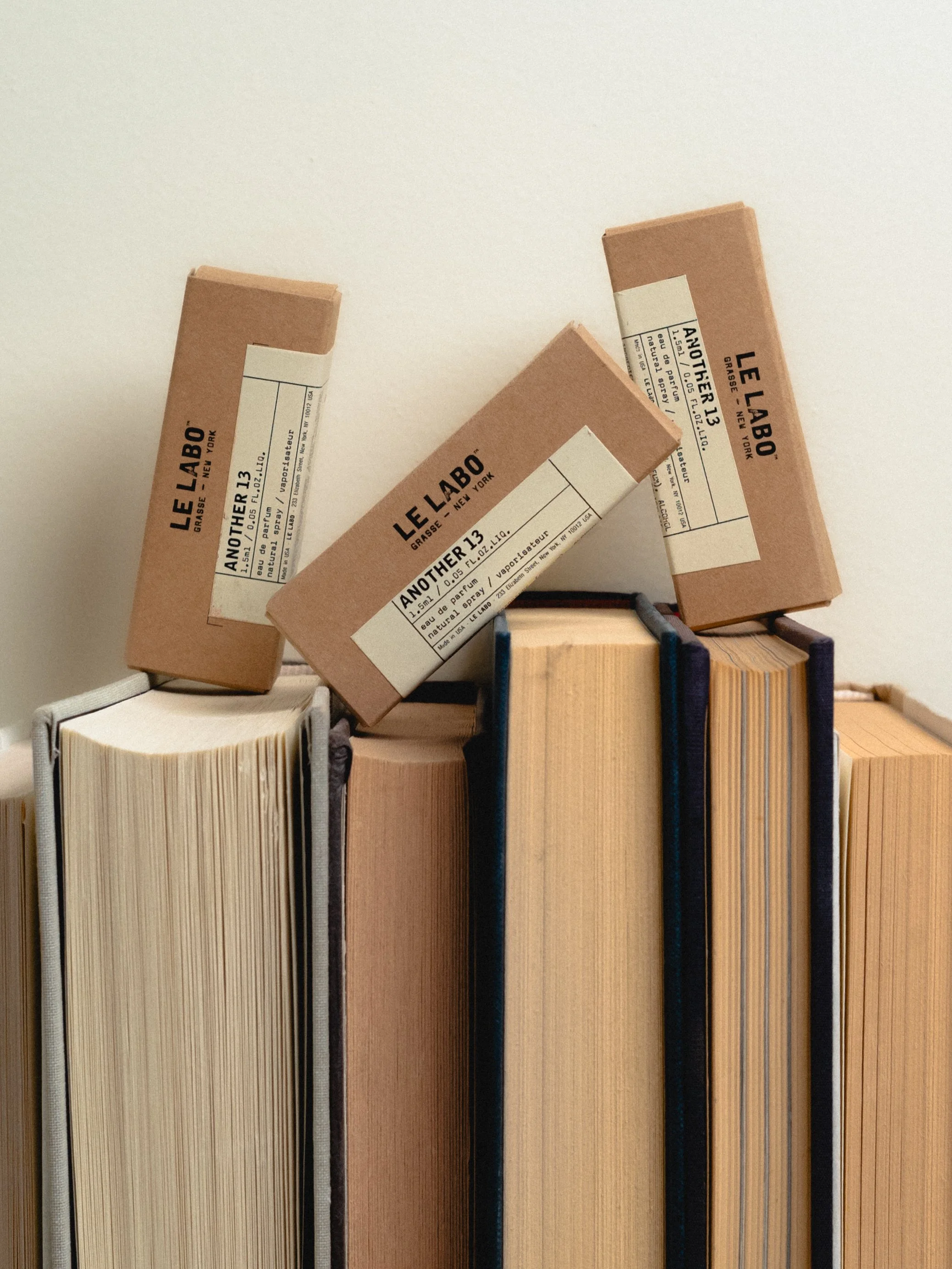 Several books with cardboard covers and white labels standing upright on a shelf.
