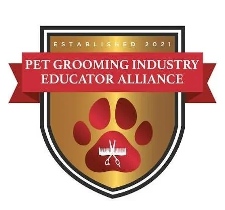 Logo for the Pet Grooming Industry Educator Alliance, established in 2021, featuring a shield with a red paw print and grooming scissors.