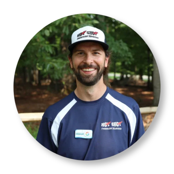 Brian Mehalso owner of Hot Shot Pressure Washing in Salem Virginia smiling in uniform in front of a property.