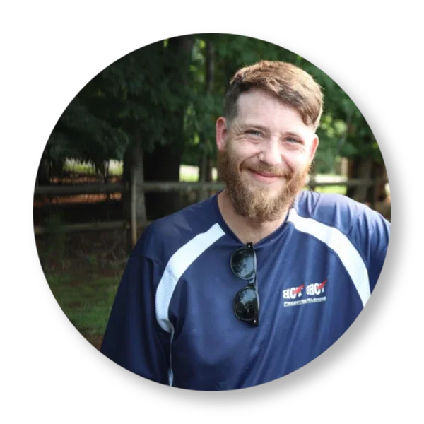 Zack Hot Shot Pressure Washing employee in Salem Virginia smiling in uniform in front of a property.