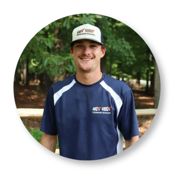 Jacob Hot Shot Pressure Washing employee in Salem Virginia smiling in uniform in front of a property.