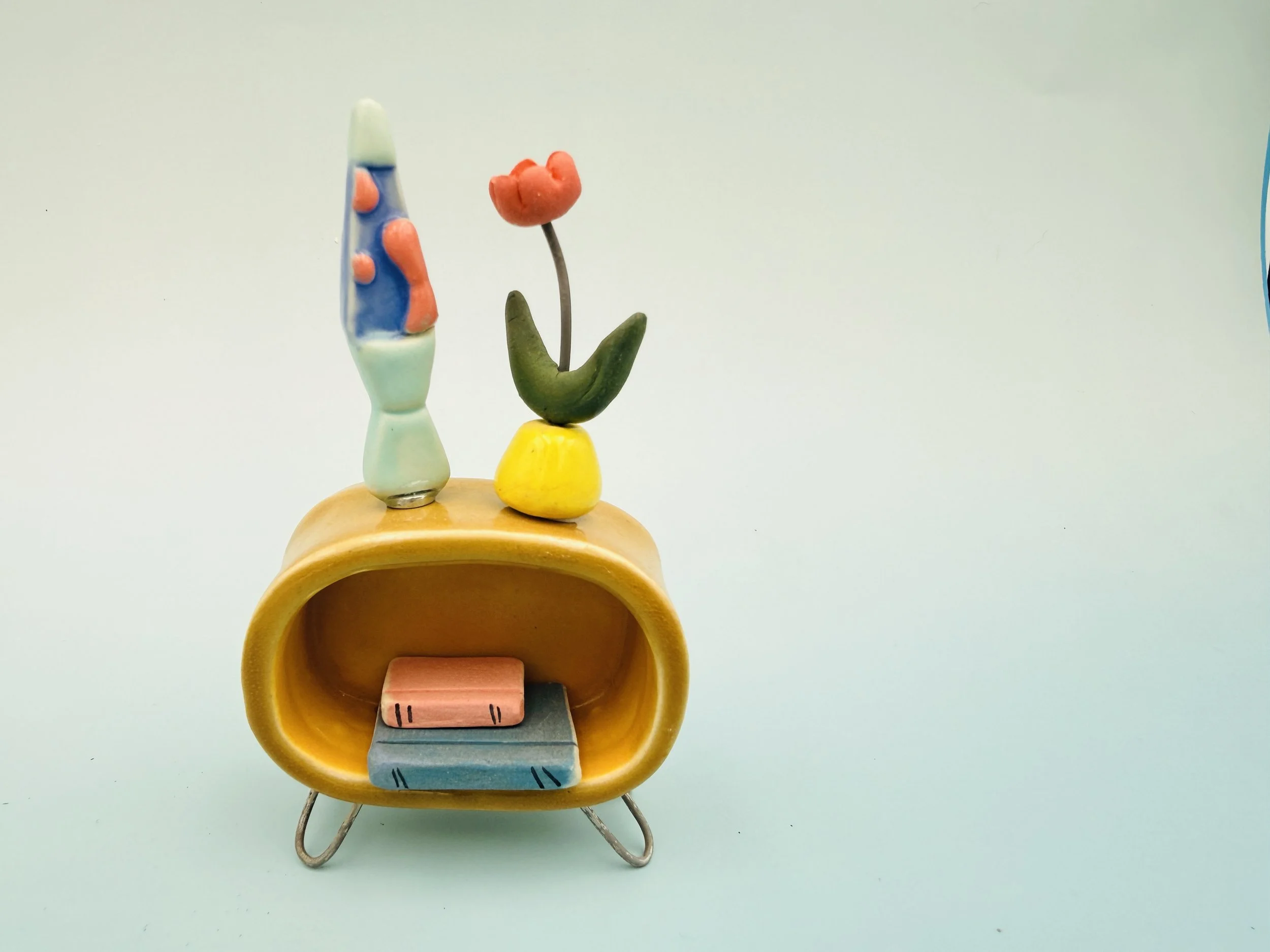 Miniature dollhouse furniture in century modern style: table, lava lamp, and potted plant