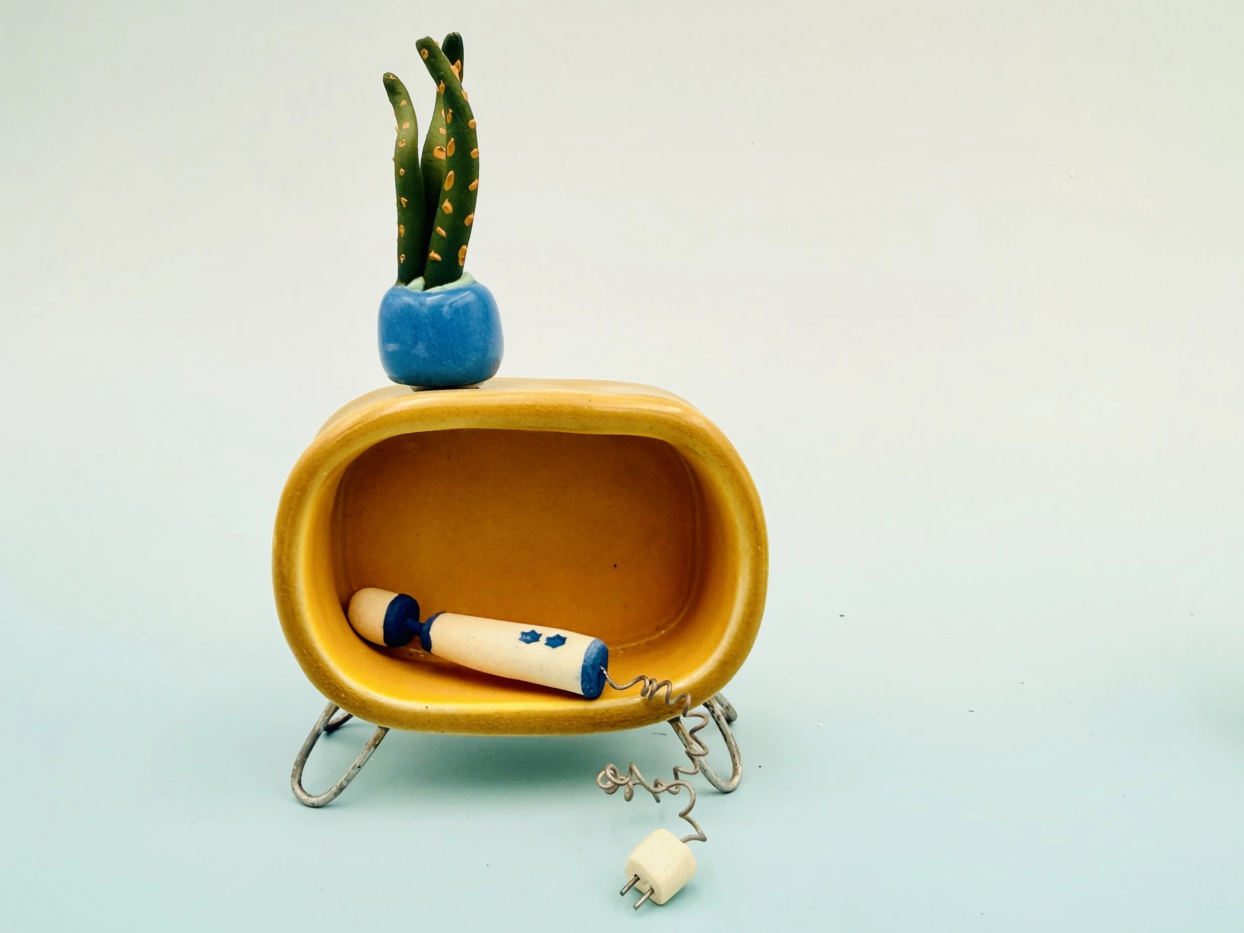 Miniature dollhouse furniture in century modern style: table, hitachi magic wand, and potted plant