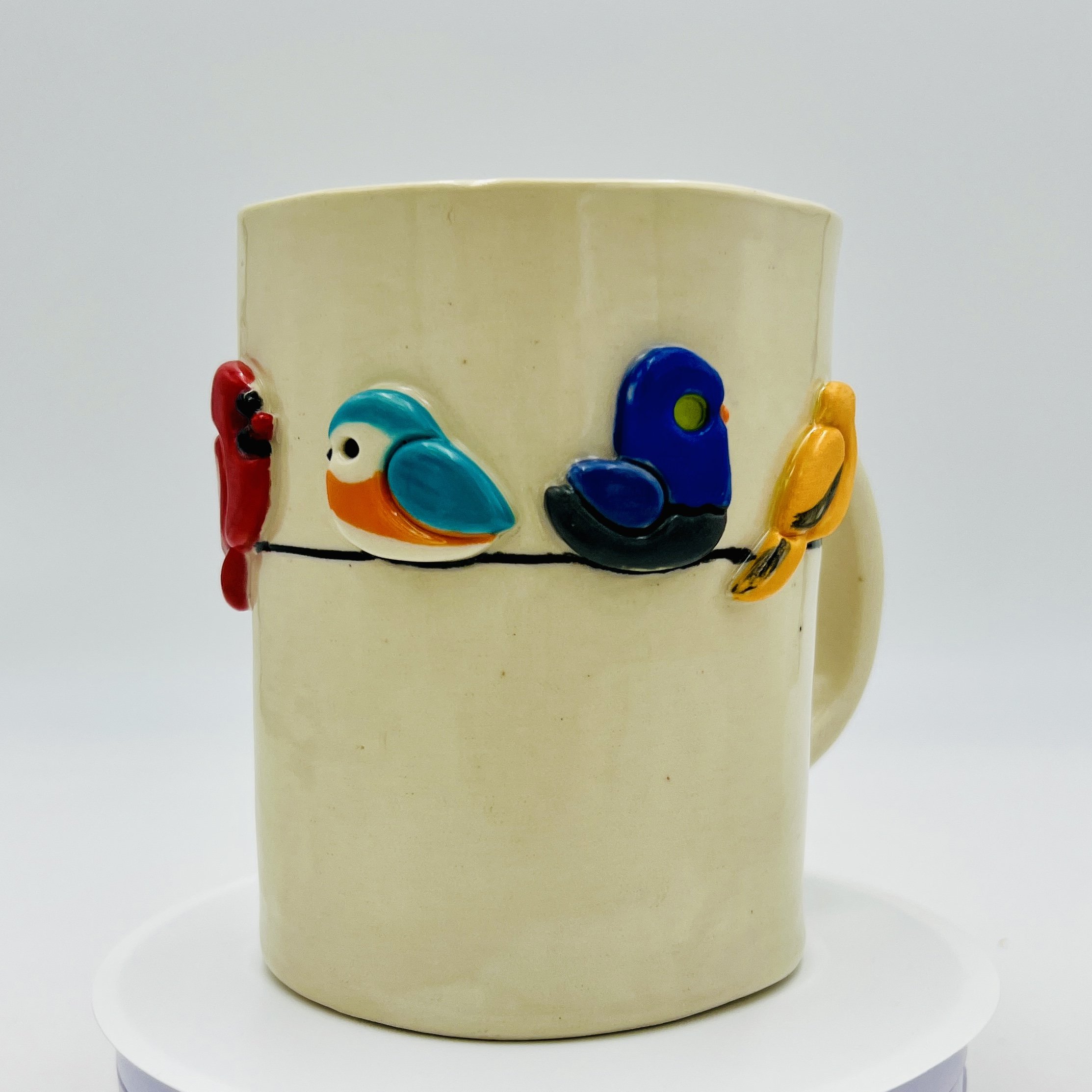 ceramic mug with birds around a wire