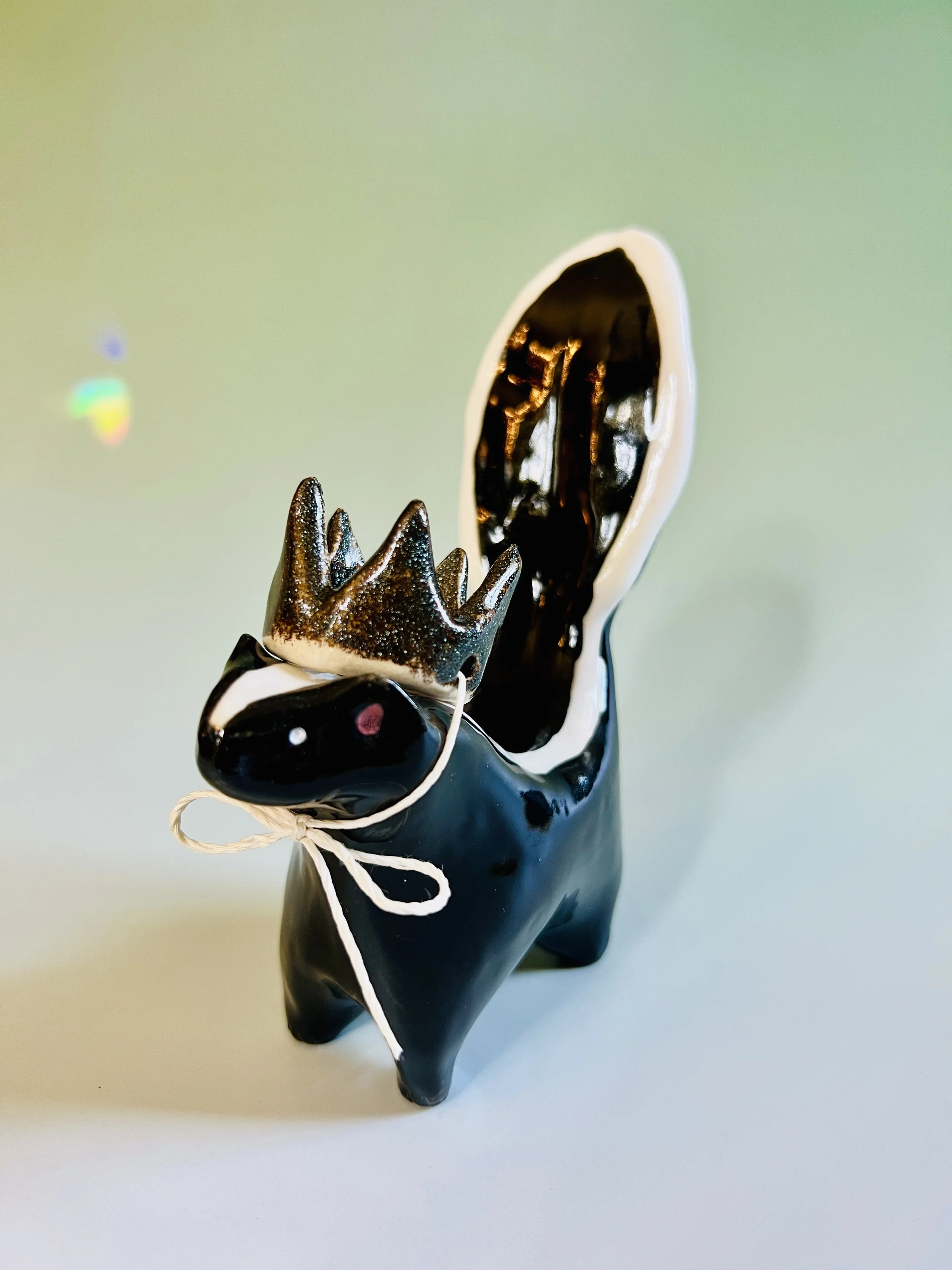  ceramic skunk wearing a crown